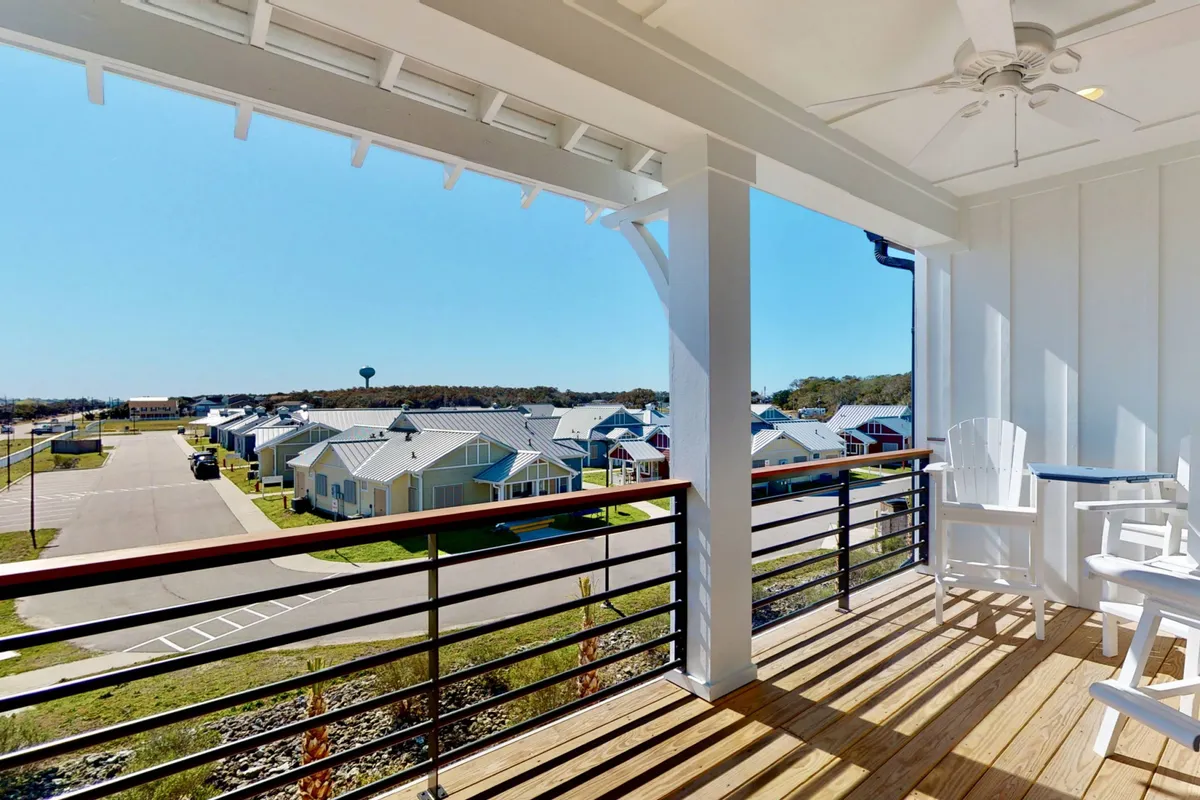 A peaceful balcony scene with comfortable outdoor seating overlooking the neighborhood. The setting is perfect for relaxing, enjoying drinks, or watching the sunset, enhancing the sense of upscale gatherings with an outdoor focus.